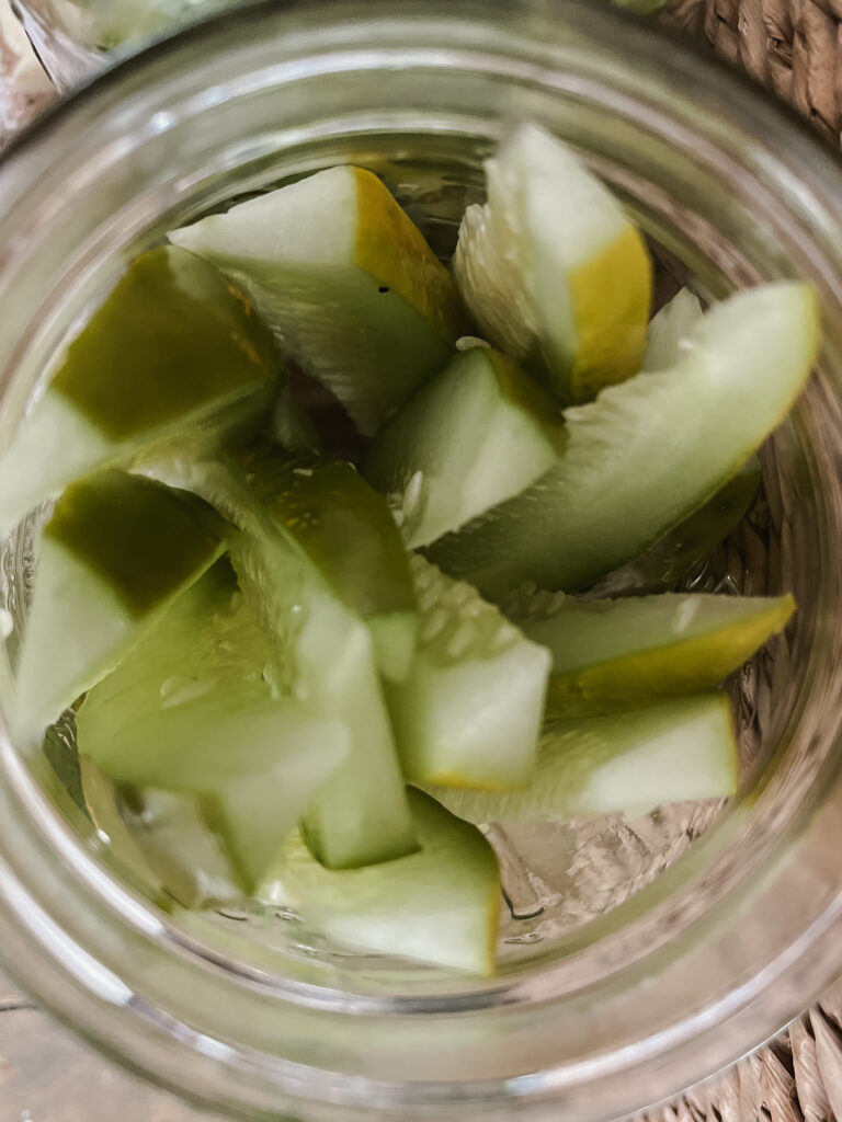 Top view of freshly sliced cucumber spears in mason jar