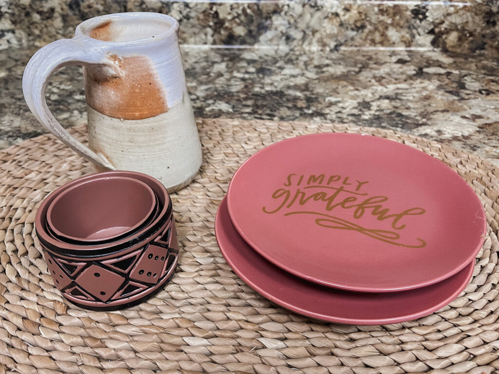 Mug, serving plates, and trinket dishes on rattan trivet